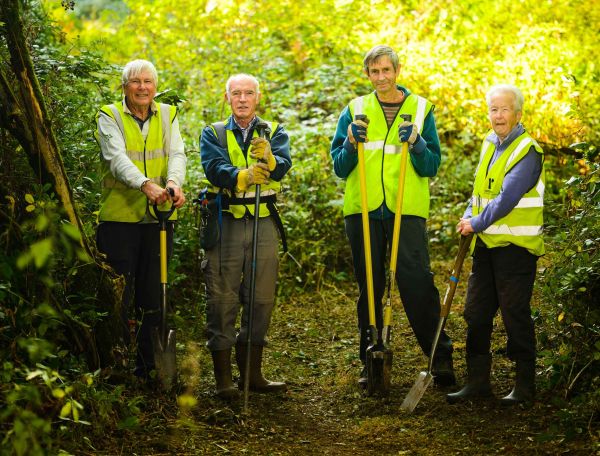 volunteers in hi-vis jackets ready to clear vegetation from footpaths