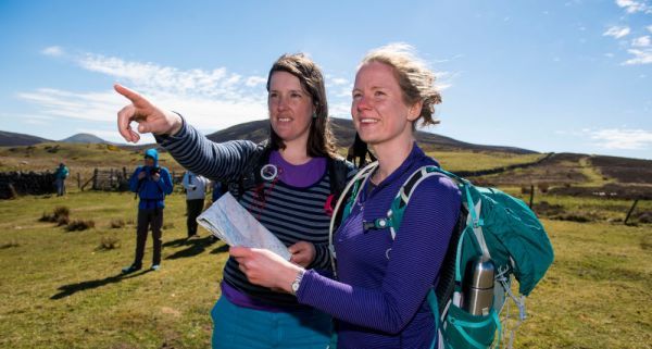 female walkers reading a map and pointing into the distance