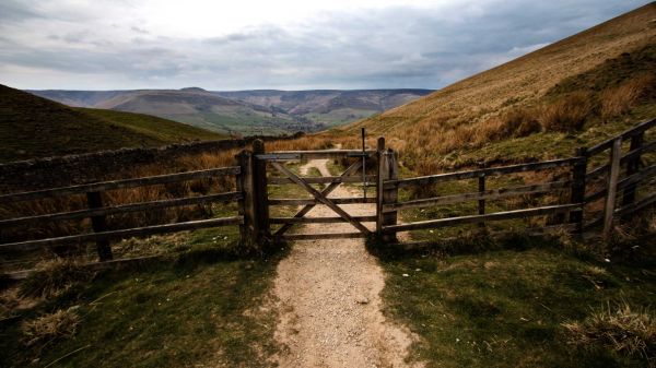 a gate on a path going through a valley