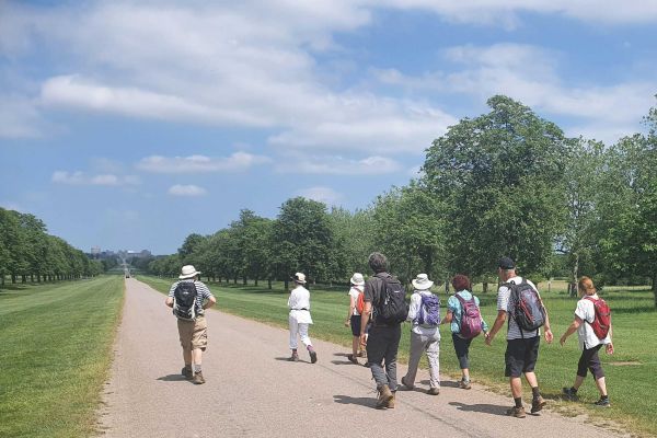 Walkers on pathed path in a well manicured park.