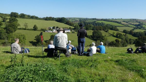 Walkers picnicking looking out on lush green hills.