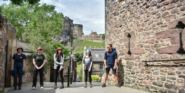 five walkers standing in front of Edinburgh castle 