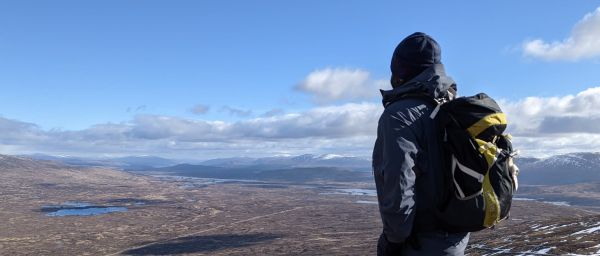 walker with backpack overlooking landscape