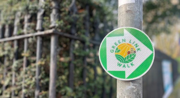 green link walk sign on a post.