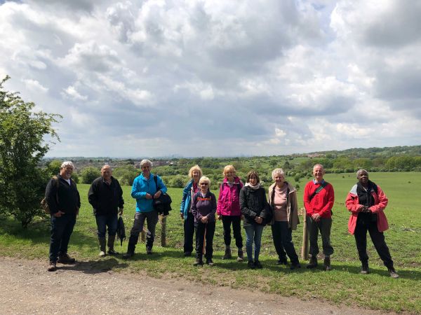 a group of walkers stood on a country path.