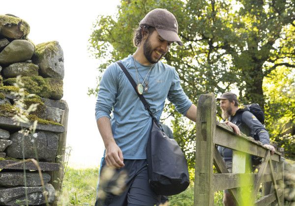 A walker heading through a gate with a tree in the background.