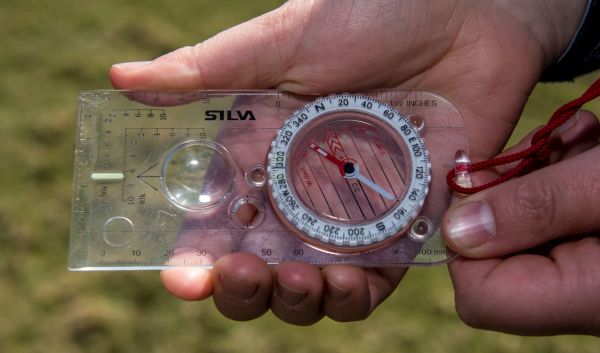 walker holding and reading a compass