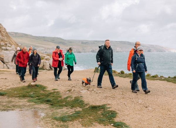 a group enjoying a coastal walk with a small dog in tow