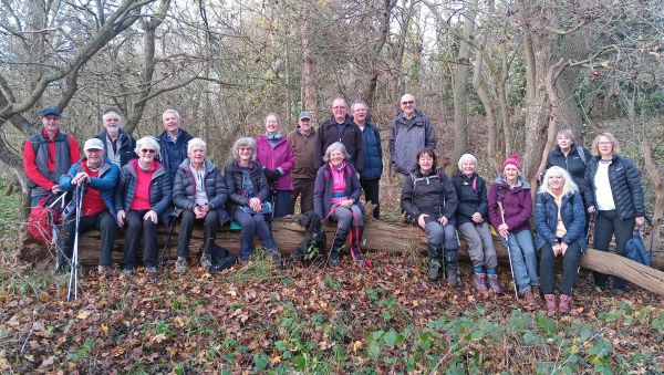 smiling walkers sat on a fallen tree trunk