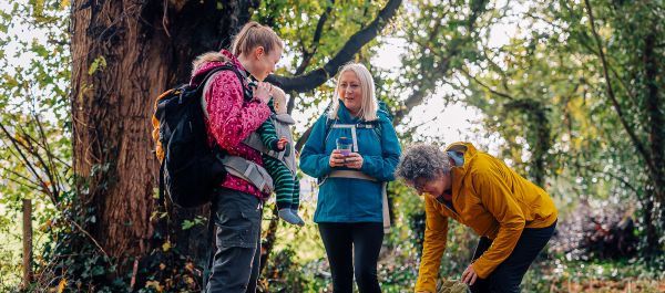 Three walkers, one carrying a baby, stop for a talk.