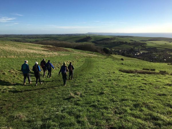 walkers going down a gentle slope with huge views in the distance