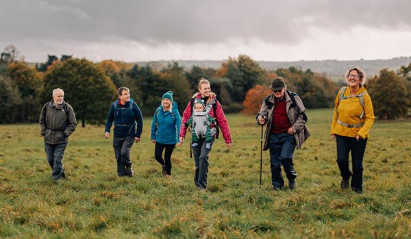 A group of people crossing a grassy field